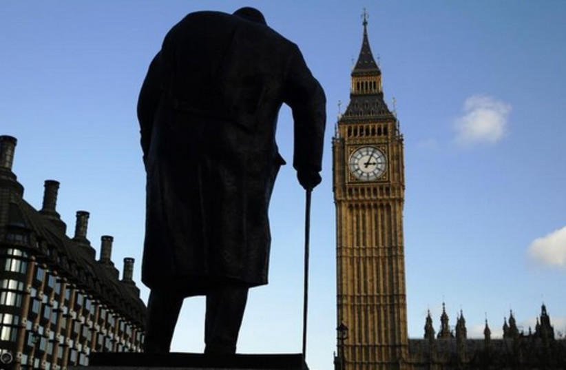 The statue of Britain's former Prime Minister Winston Churchill is silhouetted in front of the Houses of Parliament in London (photo credit: REUTERS)