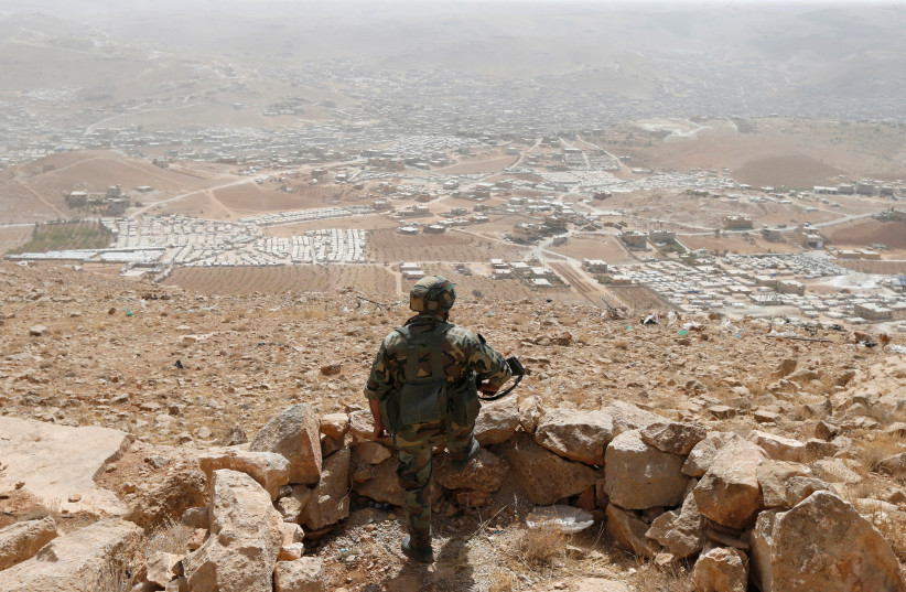 A Lebanese soldier carries his weapon as he stands at an army post in the hills above the Lebanese town of Arsal, near the border with Syria, Lebanon September 21, 2016. Picture taken September 21, 2016.  (photo credit: MOHAMED AZAKIR / REUTERS)