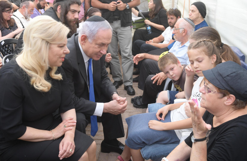 Israeli Prime Minister Benjamin Netanyahu speaks to the family members of the three people killed by a Palestinian terrorist in Halamish (photo credit: AMOS BEN-GERSHOM/GPO)