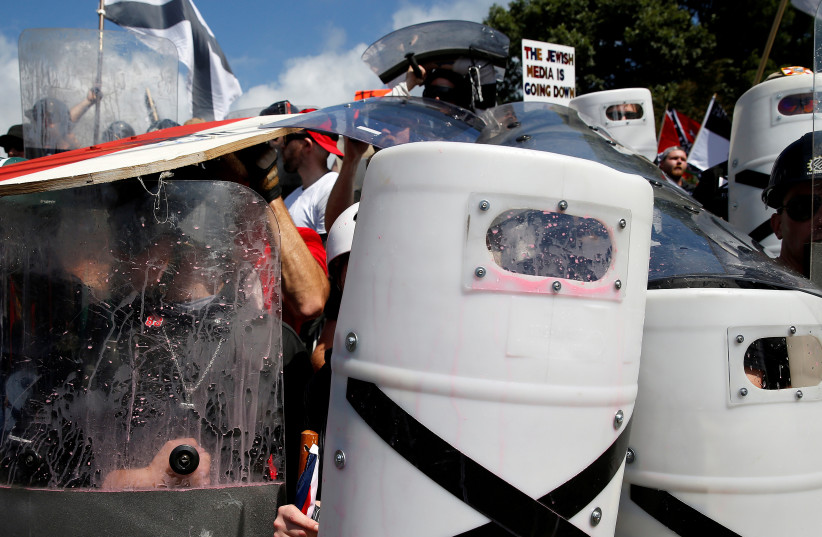 White supremacists shelter behind their shields after clashing with counter protesters at a rally in Charlottesville, Virginia, US, August 12, 2017. (photo credit: REUTERS/JOSHUA ROBERTS)