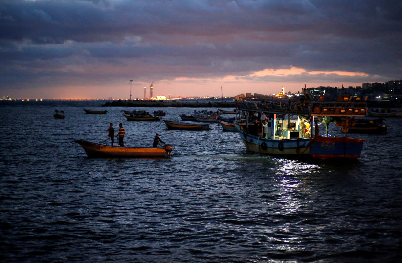 Palestinian fishermen ride their boats as they return from fishing at the seaport of Gaza City (photo credit: REUTERS/MOHAMMED SALEM)