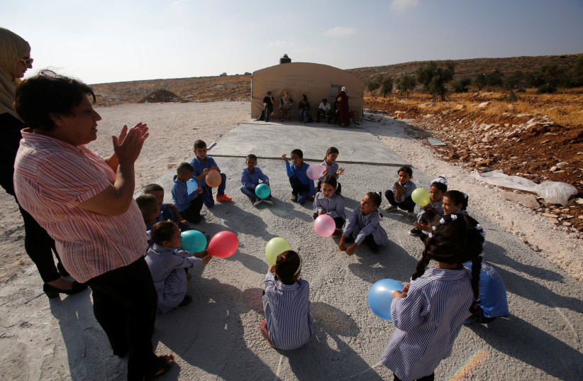 Palestinian schoolchildren play outside a tent where they attend lessons after Israeli troops razed their school building in the West Bank village of Jubbet ad-Dib, near Bethlehem August 24, 2017 (photo credit: REUTERS)