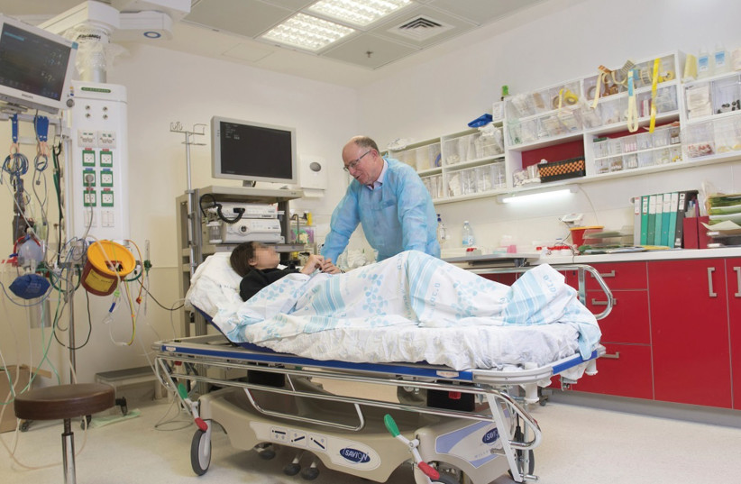 THE SEVEN-YEAR-OLD who nearly lost his life from a massive hemorrhage in his digestive tract speaks with Prof. Ron Shaul, director of the Gastroenterology Institute at Haifa’s Rambam Medical Center. (photo credit: RAMBAM HOSPITAL SPOKESMAN)