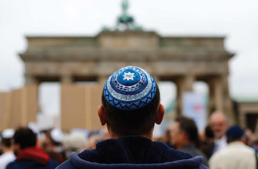 A man wearing a yarmulke looks at the Brandenburg Gate in Berlin. (photo credit: REUTERS)
