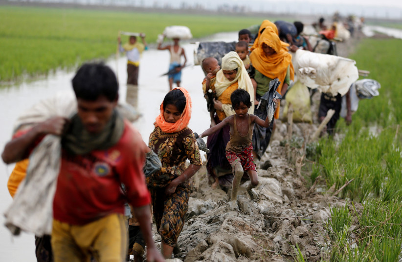 Rohingya refugees walk on the muddy path after crossing the Bangladesh-Myanmar border in Teknaf, Bangladesh, September 3, 2017. (photo credit: REUTERS)