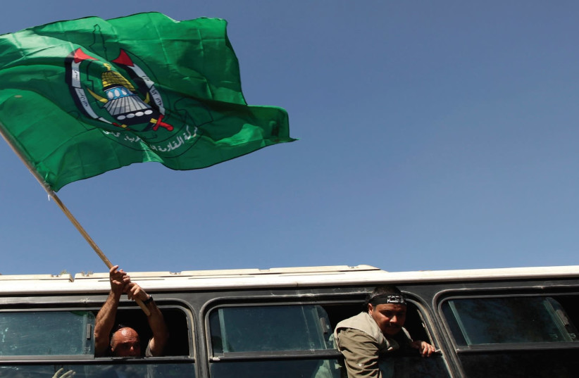 A FREED Palestinian prisoner waves a Hamas flag upon his arrival at the Rafah crossing with Egypt in the southern Gaza Strip in October, 2011. (photo credit: REUTERS)