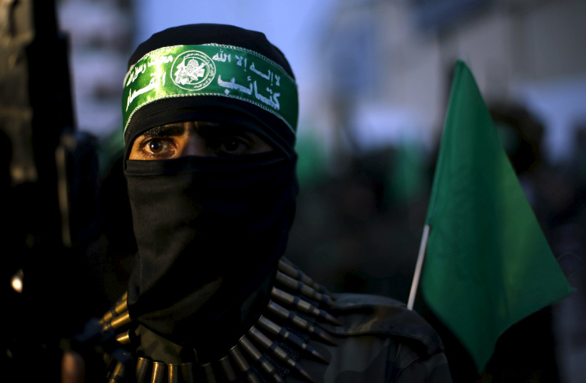 A Palestinian Hamas militant takes part in a Gaza rally marking the twelfth anniversary of the death of late Hamas leader Sheikh Ahmed Yassin. (photo credit: SUHAIB SALEM / REUTERS)