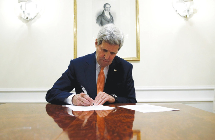 THEN-SECRETARY of state John Kerry signs the Iran deal in 2016. (photo credit: REUTERS)
