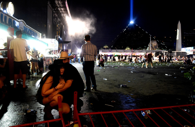  People take cover at the Route 91 Harvest country music festival in Las Vegas after gun fire was heard (photo credit: DAVID BECKER/GETTY IMAGES/AFP)