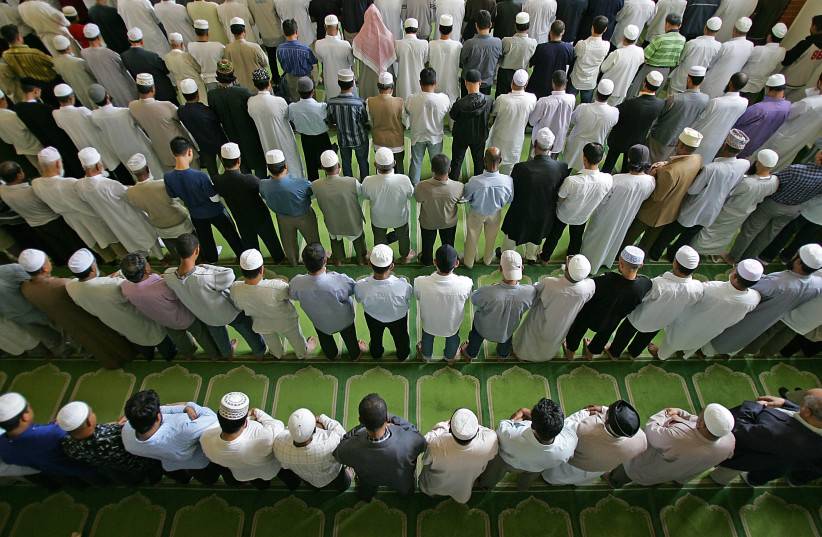 British muslims pray during Friday prayer at the East London mosque. (photo credit: ODD ANDERSEN / AFP)