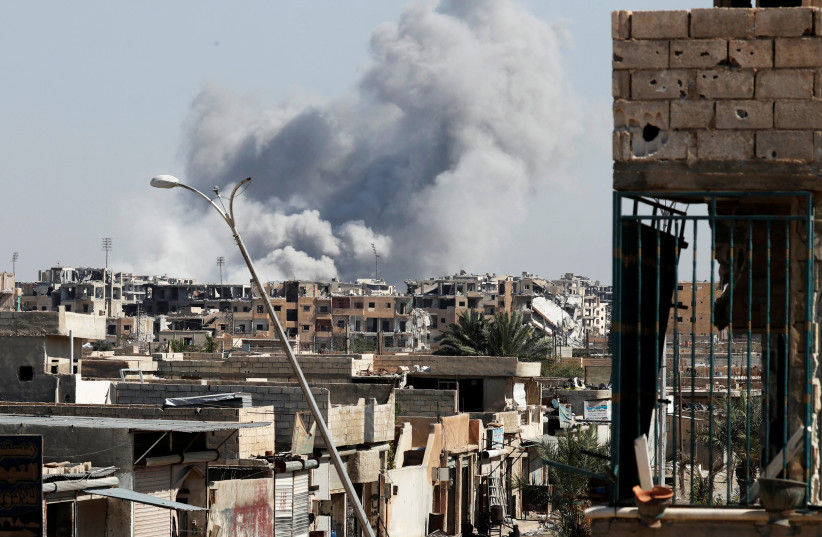 Smoke rises near the stadium where the Islamic State militants are holed up after an air strike by coalition forces at the frontline, in Raqqa, Syria  (photo credit: ERIC DE CASTRO/ REUTERS)