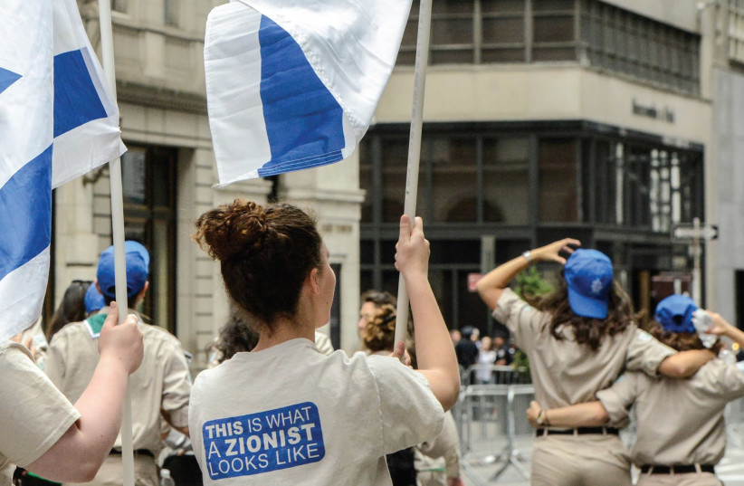 A PARTICIPANT wears a shirt that reads ‘This is what a Zionist looks like’ while participating in a parade along 5th Ave. in New York City, in June (photo credit: REUTERS)