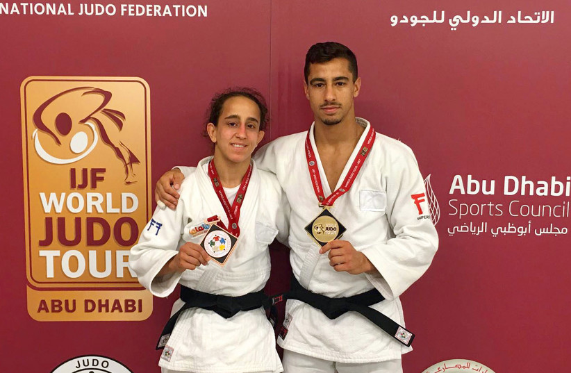 Israeli judokas Gili Cohen, winner of the bronze medal in the Women's -52kg, and Tal Flicker, winner of the gold medal in the Men's -66kg category at the Abu Dhabi Judo Grand Slam (photo credit: AFP PHOTO / HO / ISRAEL JUDO FEDERATION)
