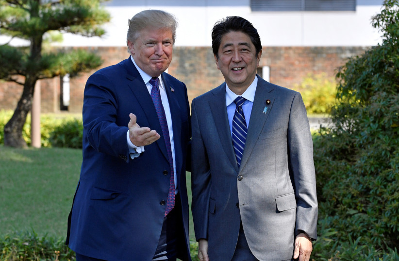 US President Donald Trump (L) gestures with Japanese Prime Minister Shinzo Abe upon his arrival at the Kasumigaseki Country Club in Kawagoe, near Tokyo, Japan, 05 November 2017 (photo credit: REUTERS/FRANK ROBICHON/POOL)
