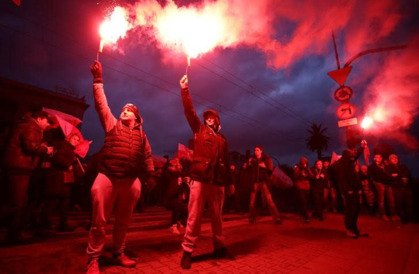 Protesters light flares and carry Polish flags during a rally, organised by far-right, nationalist groups, to mark 99th anniversary of Polish independence in Warsaw, Poland November 11, 2017 (photo credit: AGENCJA GAZETA/ADAM STEPIEN VIA REUTERS)