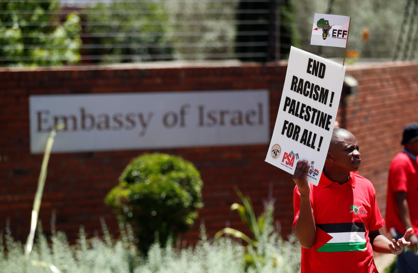 A protester and member of South Africa's ultra-left Economic Freedom Fighters party (EFF), carries a placard outside the Israeli embassy in Pretoria, South Africa (photo credit: SIPHIWE SIBEKO/REUTERS)
