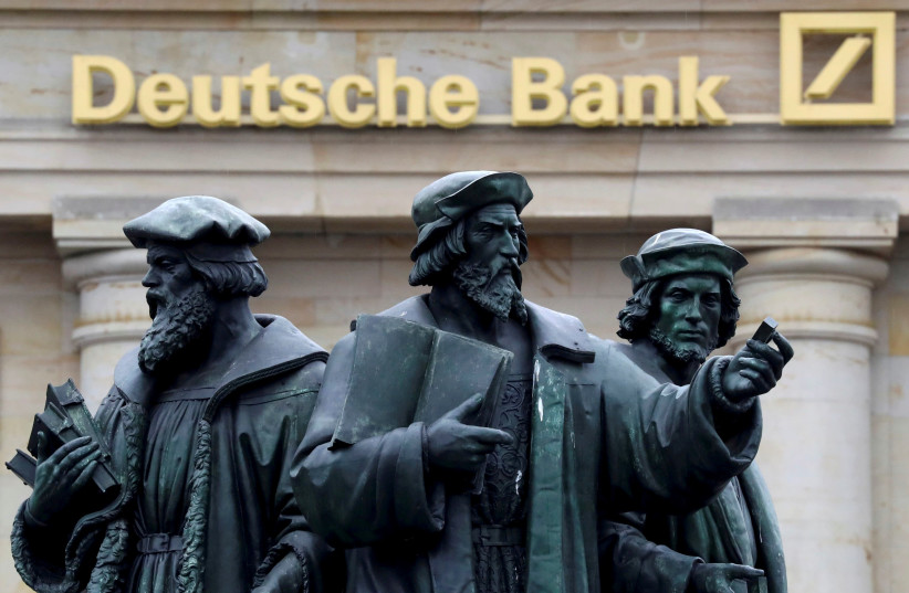 A statue is pictured next to the logo of Germany's Deutsche Bank in Frankfurt, Germany. (photo credit: REUTERS)