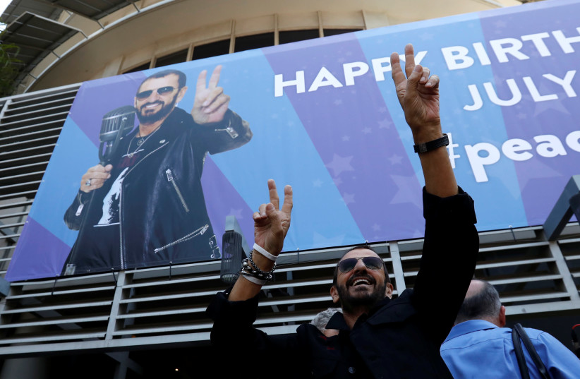 Musician Ringo Starr gestures at fans at a 'Peace & Love' event to celebrate Starr's 77th birthday in Los Angeles, California. (photo credit: REUTERS)