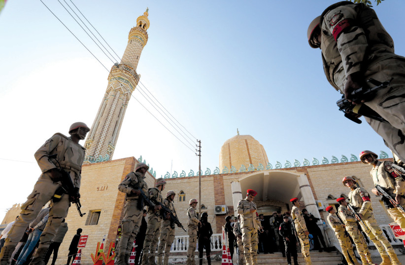 EGYPTIAN SOLDIERS watch over worshipers outside Al Rawdah mosque earlier this month after the deadly November 24 terrorist attack in Bir Al-Abed, Egypt (photo credit: MOHAMED ABD EL GHANY/REUTERS)