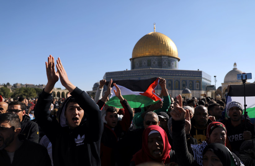 Worshippers chant as they wave Palestinian flags after Friday prayers on the compound known to Muslims as Noble Sanctuary and to Jews as Temple Mount in Jerusalem's Old City (photo credit: AMMAR AWAD / REUTERS)