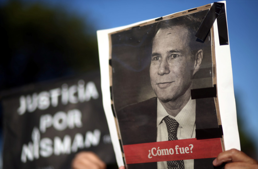 A woman holds up a photo of late state prosecutor Alberto Nisman, lead investigator into the car bomb attack that killed 85 people at a Buenos Aires' Jewish community center, during commemorations of the second anniversary of his death in Buenos Aires, Argentina, January 18, 2017. (photo credit: REUTERS)