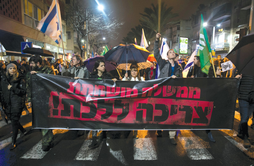 PROTESTERS CALL for the resignation of Prime Minister Benjamin Netanyahu over police investigations for suspected corruption at a demonstration in Tel Aviv in January. The banner says ‘A corrupt government must go.’ (photo credit: BAZ RATNER/REUTERS)