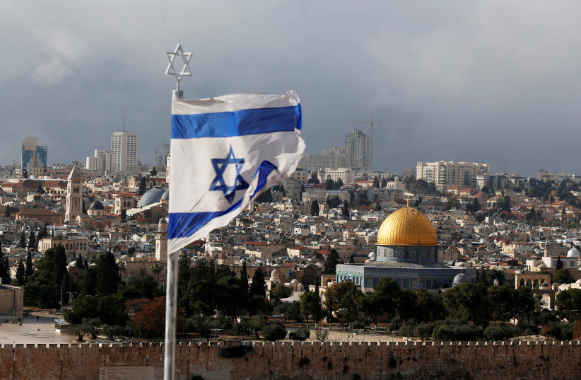 An Israeli flag is seen near the Dome of the Rock, located in Jerusalem's Old City  (photo credit: AMMAR AWAD / REUTERS)