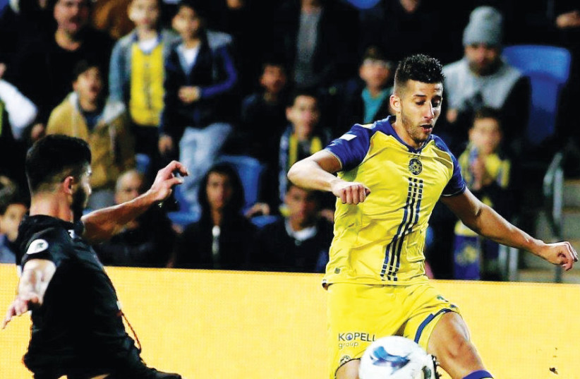 Two days after signing a four-year contract extension, Maccabi Tel Aviv midfielder Dor Micha (right) set up his team’s opener in last night’s 3-0 victory over Bnei MMBE in the State Cup round-of-32. (photo credit: ADI AVISHAI)
