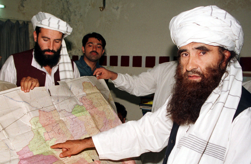 FILE PHOTO: Jalaluddin Haqqani points to a map of Afghanistan during a visit to Islamabad, Pakistan while his son Naziruddin looks on in 2001 (photo credit: REUTERS/STRINGER/FILES)
