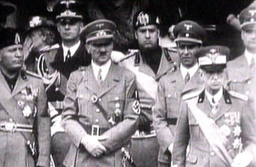 King Victor Emanuel III, (R) Adolf Hitler (C) and Benito Mussolini (L) watch fascist troops march past from a balcony in central Rome in this 1941 television file footage. (photo credit: REUTERS TV)