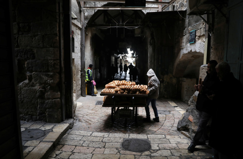 A man sells bread in the nearly-empty Muslim quarter of Jerusalem's Old City during the Palestinian's general strike against US VP Pence's visit, January 2018 (photo credit: AMMAR AWAD/REUTERS)