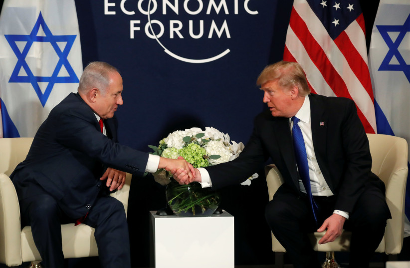 US President Donald Trump shakes hands with Israeli Prime Minister Benjamin Netanyahu during the World Economic Forum meeting in Davos, Switzerland (photo credit: CARLOS BARRIA / REUTERS)