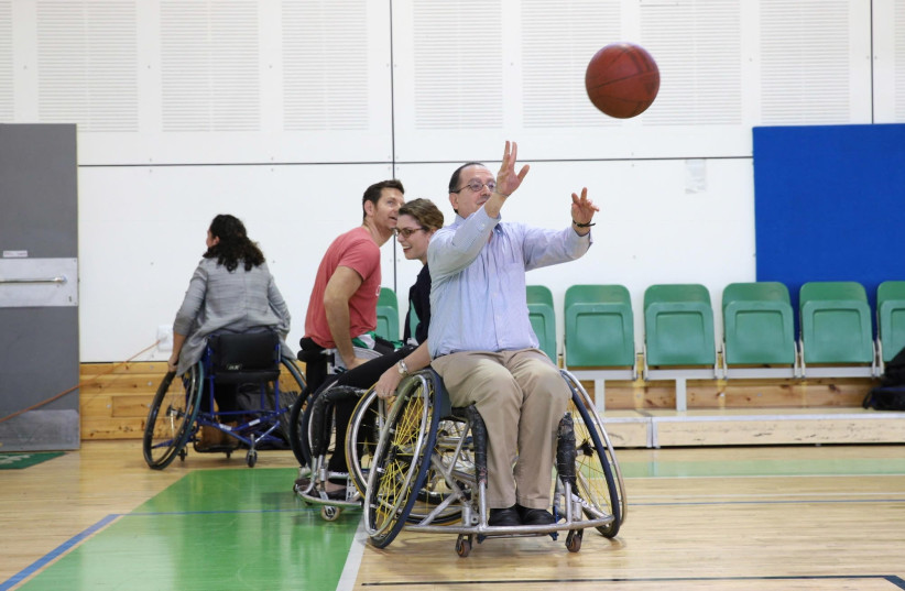  David Schizer, JDC CEO, plays basketball with disabled Israelis at the Spivack gymnasium in Ramat Gan. The game, last month, was a part of a program aimed at integrating people with disabilities into Israeli society through sport (photo credit: CHEN GALILI FOR JDC)