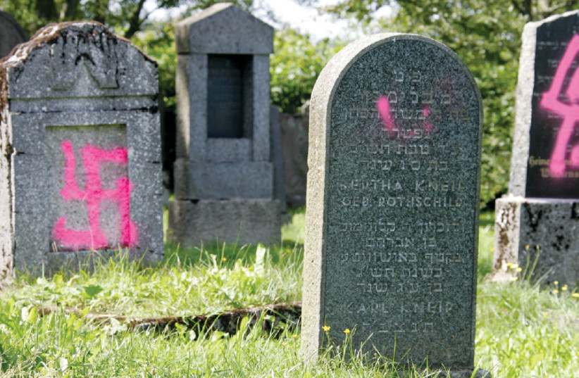 GRAVES DESECRATED by vandals with Nazi swastikas and antisemitic slogans are seen in the Jewish cemetery of Weyhers, near the western German town of Ebersburg in 2005 (photo credit: FABRIZIO BENSCH / REUTERS)