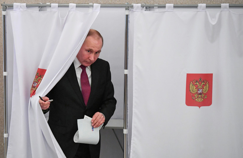 Russian President and Presidential candidate Vladimir Putin at a polling station during the presidential election in Moscow, Russia March 18, 2018 (photo credit: REUTERS/YURI KADOBNOV/POOL)