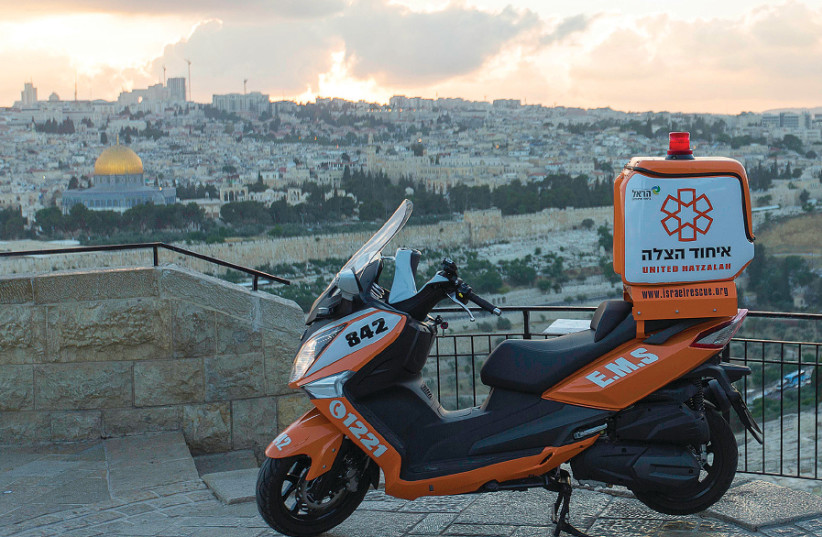 A UNITED HATZALAH ambucycle is seen with Jerusalem in the background (photo credit: SHIRA HERSHKOPF/UNITED HATZALAH)