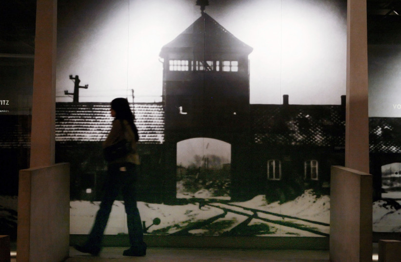 A visitor to the US Holocaust Memorial Museum walks past a mural of the Auschwitz-Birkenau concentration camp in Washington, January 26, 2007 (photo credit: REUTERS/JIM YOUNG)