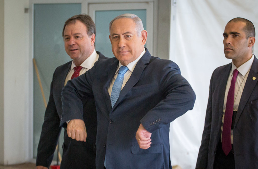 Prime Minister Benjamin Netanyahu gestures chicken wings as he enters a cabinet meeting, in honor of Netta Barzilai winning Eurovision, May 13th, 2018. (photo credit: EMIL SALMAN/POOL)