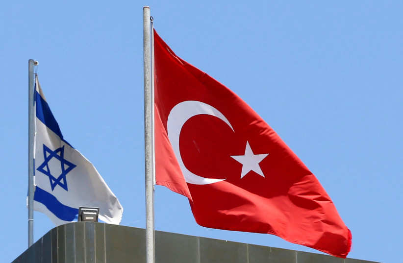 A Turkish flag flutters atop the Turkish embassy as an Israeli flag is seen nearby, in Tel Aviv, Israel June 26, 2016 (photo credit: REUTERS/BAZ RATNER)