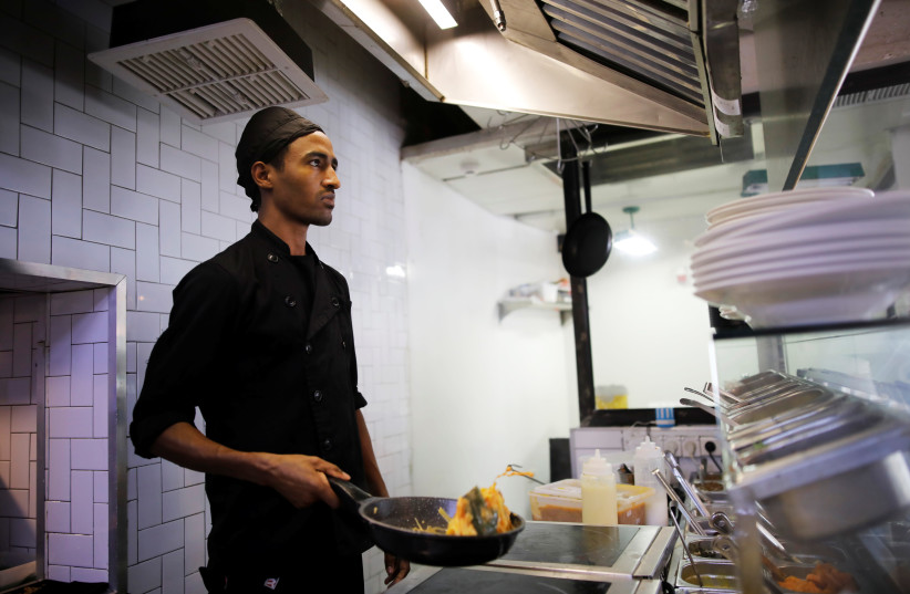 Teklit Michael, 29, an asylum seeker from Eritrea, works in the kitchen of a restaurant in Tel Aviv, Israel (photo credit: AMIR COHEN/REUTERS)