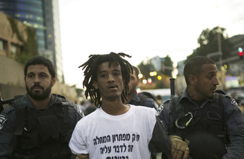 ISRAEL POLICE detain a protester during a 2015 anti-racism demonstration in Tel Aviv. (photo credit: AMIR COHEN/REUTERS)