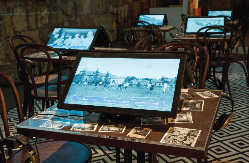 Laptops sit on the tables of the recreated Smadar Cinema cafe at the Tower of David exhibition. (photo credit: ODED ANTMAN)
