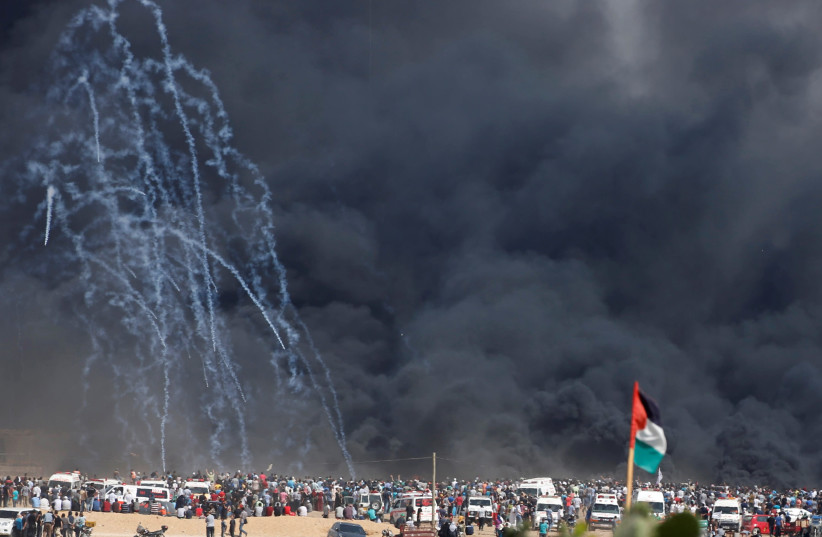 Tear gas canisters are fired by Israeli troops at Palestinian demonstrators during a protest marking al-Quds Day, (Jerusalem Day), at the Israel-Gaza border east of Gaza City June 8, 2018. (photo credit: MOHAMMED SALEM/ REUTERS)