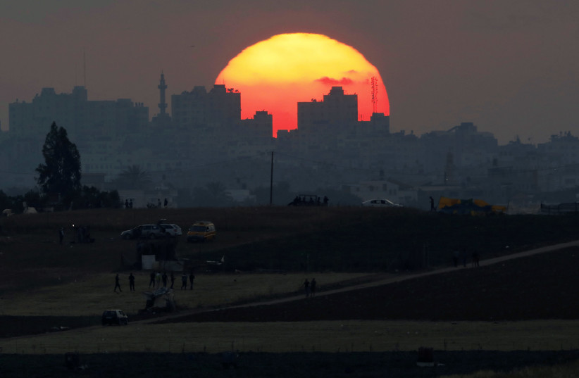 The sun sets over the Gaza Strip, as seen from the Israeli side of the border May 15, 2018 (photo credit: REUTERS/AMIR COHEN)