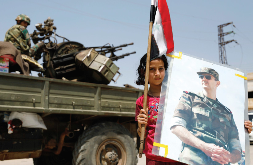 A GIRL holds an image of Syrian President Bashar Assad. (photo credit: REUTERS)