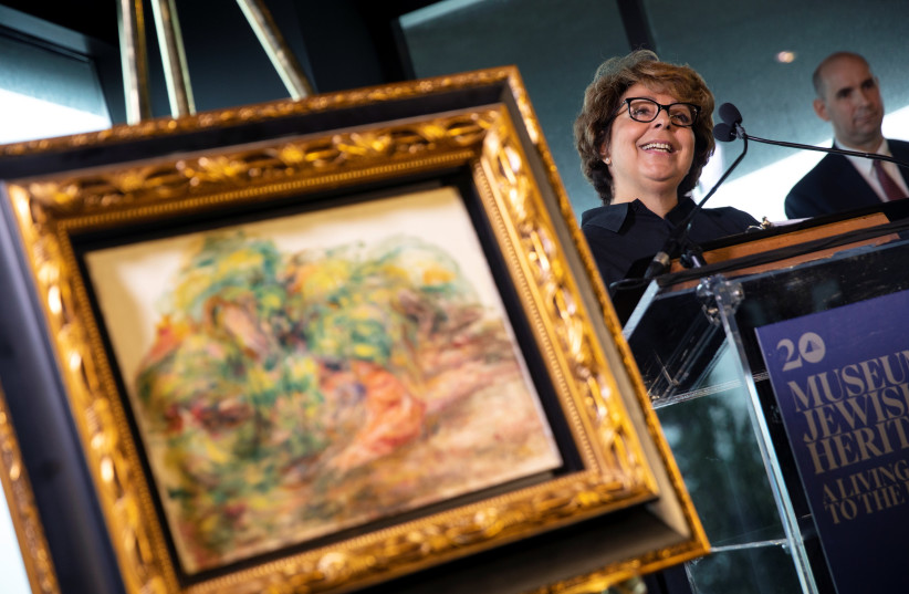Sylvie Sulitzer speaks next to the painting Deux Femmes Dans Un Jardin by Pierre Auguste Renoir during a ceremony to return the painting, stolen by the Nazis in World War II from Ms. Sulitzer's family, at the Jewish Heritage Museum in New York City, New York, U.S., September 12, 2018. (photo credit: MIKE SEGAR / REUTERS)