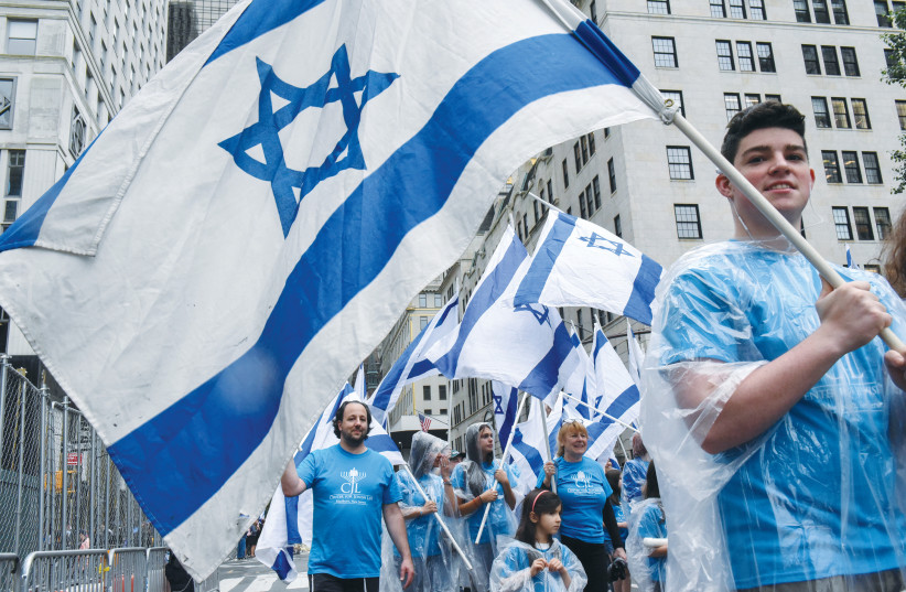 Participants carry Israeli flags at the 'Celebrate Israel'' parade along Fifth Avenue in New York City in 2017 (photo credit: STEPHANIE KEITH/REUTERS)