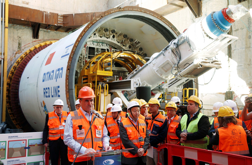 Yisrael Katz, Israel's Minister of Transport, speaks as he stands next to employees of China Railway Engineering Corporation, during an event marking the beginning of underground construction work of the light rail, using a Tunnel Boring Machine (TBM), in Tel Aviv, Israel February 19, 2017. (photo credit: BAZ RATNER/REUTERS)