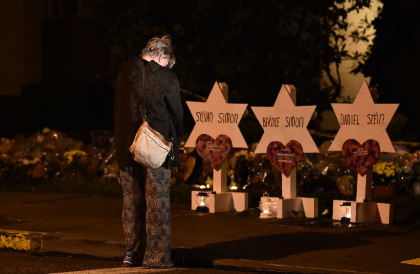 A woman bows her head in front of a memorial on October 28, 2018, at the Tree of Life synagogue after a shooting there left 11 people dead in the Squirrel Hill neighborhood of Pittsburgh on October 27 (photo credit: BRENDAN SMIALOWSKI / AFP)