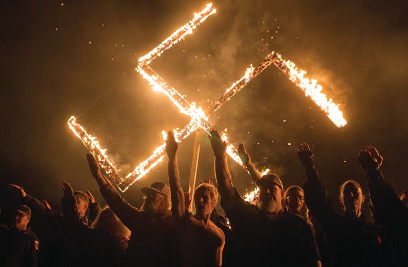 SUPPORTERS OF THE National Socialist Movement give Nazi salutes while taking part in a swastika-burning in Georgia in April.  (photo credit: GO NAKAMURA/REUTERS)